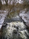 River flowing through Winter scene of snow covered fields