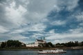 The river flows through the city. Church on the hill above the river. Wisla River in Krakow. Float the boat and the ship under wat Royalty Free Stock Photo