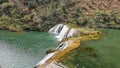 River flows down a hillside by a verdant forest in Jiulong Waterfalls China Royalty Free Stock Photo