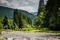 The river flows between green mountains