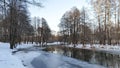 The river flows through a mixed forest. There are ice edges and ripples on the water. There\'s snow everywhere. Alder trees and ot Royalty Free Stock Photo