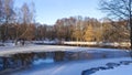 The river flows through a mixed forest. There are patches of ice in the open water. There is snow everywhere. Alders, birches and Royalty Free Stock Photo