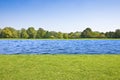 A river flows quietly on a flat land with mowed lawn and trees Royalty Free Stock Photo