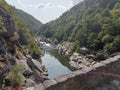 a river flows through a rocky gorge surrounded by trees and hills Royalty Free Stock Photo