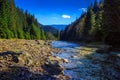 River flows by rocky shore near the autumn mountain forest Royalty Free Stock Photo