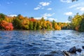 River through a forest at the peak of fall foliage on a clear day Royalty Free Stock Photo