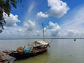 River Ganges with floating boat on a sunny day with blue sky and white cotton like cloud at Gadiara