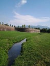 River, grassland, and the ancient city wall of Luca, Italy