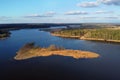 River island and forest aerial view. Storage reservoir. Aerial shot of spring landscape with blue sky and white clouds, flat