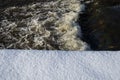 River landscape. Flowing water and snow. Natural winter background pattern. Royalty Free Stock Photo