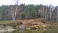 River landscape in late autumn. The high river bank with sandy bluffs is overgrown with birches and pines. Leaves have fallen off. Royalty Free Stock Photo