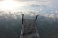 River Landscape of old iron dock looks like a ladder to clouds. Stairway to heaven concept. Royalty Free Stock Photo
