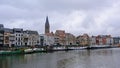 River Lys with housing boats and quay with houses and church in Ghent