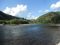 River and mountains against the blue sky and clouds