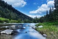 River in mountains with rocks, green grass on riverside. Mountain landscape, beautiful sky, clouds. Idea for outdoor activities, Royalty Free Stock Photo