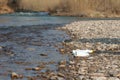 River pollution near the shore, garbage near the river, plastic food waste, contributing to pollution