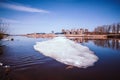 River quietly flowing flows in early spring when there is still ice and snow. Spring cityscape. Royalty Free Stock Photo