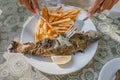 River rainbow trout baked according to old Turkish recipe in a grape or sycamore leaf in a restaurant on a plate with French Royalty Free Stock Photo