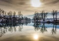 River reflection of trees and a yellow sun Royalty Free Stock Photo