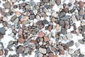 River rock gravel mulch in grey and red colors in winter with a light covering of snow
