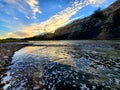 River rock  sunset surf beach Royalty Free Stock Photo