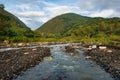 Streams and rocks between mountains with blue sky and green trees Royalty Free Stock Photo