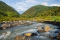 Streams and rocks between mountains with blue sky and green trees Royalty Free Stock Photo