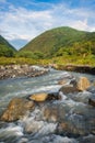 Streams and rocks between mountains with blue sky and green trees Royalty Free Stock Photo