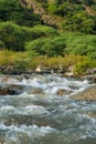 Streams and rocks between mountains with blue sky and green trees Royalty Free Stock Photo