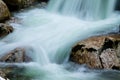 River rocks in smooth satin water flow of waterfall in wintertime Royalty Free Stock Photo