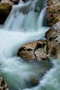 River rocks in smooth satin water flow of waterfall in wintertime Royalty Free Stock Photo