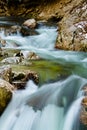 River rocks in smooth satin water flow of waterfall in wintertime Royalty Free Stock Photo