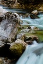 River rocks in smooth satin water flow of waterfall in wintertime Royalty Free Stock Photo