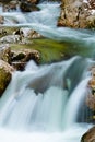 River rocks in smooth satin water flow of waterfall in wintertime Royalty Free Stock Photo