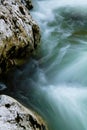 River rocks in smooth satin water flow of waterfall in wintertime Royalty Free Stock Photo