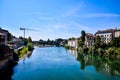 A river runs through a town with a bridge in the background Royalty Free Stock Photo