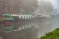 River with several boats during mist in Rotterdam, Netherlands