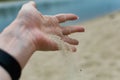 River shells and fine white river sand fall from a woman`s hand Royalty Free Stock Photo