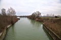 River with the sky and the trees at the edge of it casted in the water in the italian countryside in winter Royalty Free Stock Photo