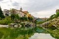 River Soca in Slovenia - Kanal ob Soci city with a beautiful old stone arch bridge and reflection in water. Royalty Free Stock Photo