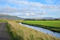 River stre train fields agriculture green blue skies long grass