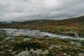 river stream going through stones and hills on field, Norway, Hardangervidda Royalty Free Stock Photo