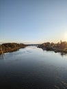 The river stretches beneath a charming bridge