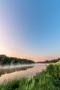 River at sunrise. the mist over the water. the vertical frame. in the sky you can see the plane Royalty Free Stock Photo