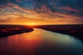 a river with a sunset in the background and trees around it and a sky filled with clouds above it