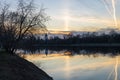 River, sunset, trees and towers of the Izmailovsky Kremlin in the background. Tree without foliage on the river bank. Twilight.