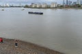 People walk on the exposed shoreline on the River Thames at low water in Greenwich