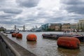 River themes, small boats docked. Cloudy sky above.