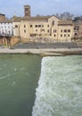 river Tiber with greenish waters and revolts in the transition zone of small cascade, Rome. Italy.