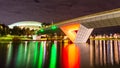 A Foot Bridge crossing a river and Sports Stadium at Night